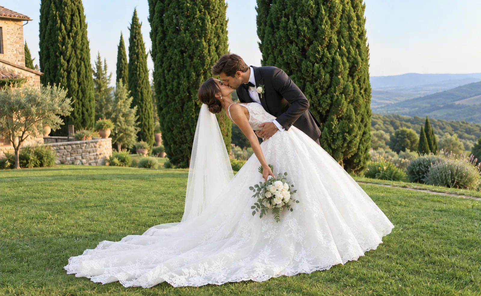 A bride and groom kissing on a lawn lined with cypress trees